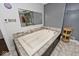 Relaxing bathroom with a large jetted tub and gray tile at 6348 Kingsley Dr, Indianapolis, IN 46220