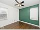Bedroom with hardwood floors and a green accent wall at 6348 Kingsley Dr, Indianapolis, IN 46220
