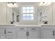 Double vanity bathroom with white cabinets and a large window at 6422 Norwich Dr, Brownsburg, IN 46112