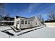 Side view of tan house with snowy yard and shed at 810 W 2Nd St, Anderson, IN 46016