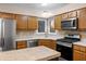 Kitchen featuring wooden cabinets, stainless steel appliances, and tile backsplash at 1633 Park Ridge Way, Indianapolis, IN 46229