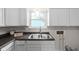 Bright kitchen features white cabinets, double sink, and granite countertops at 3125 N Tacoma Ave, Indianapolis, IN 46218