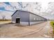 Exterior view of a long barn with garage doors and multiple windows at 432 500 N, Anderson, IN 46012