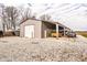Exterior view of a large garage with covered parking and gravel driveway at 432 500 N, Anderson, IN 46012