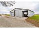 Large metal barn/garage with gravel driveway and trailer parked inside at 432 500 N, Anderson, IN 46012
