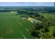 Scenic aerial view showcasing a house nestled among fields and trees with a tranquil pond at 4832 E 200 N, Anderson, IN 46012
