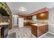 Kitchen with wood cabinets, white appliances, and brick accent wall at 4832 E 200 N, Anderson, IN 46012