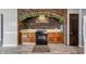 Kitchen with wood cabinets, black appliances, and brick archway at 4832 E 200 N, Anderson, IN 46012