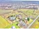 Aerial view of property showcasing a house, barn, pond, and surrounding fields at 7021 Bellsville Pike, Columbus, IN 47201