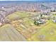 Aerial view showing a large property with farmlands, a pond, and multiple buildings at 7021 Bellsville Pike, Columbus, IN 47201