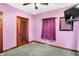 Purple bedroom with gray carpet, ceiling fan, and shoe rack on door at 2335 Union St, Indianapolis, IN 46225