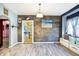 Dining area with gray wood-look floors, wood accent wall, window seating, and view of the kitchen at 2335 Union St, Indianapolis, IN 46225