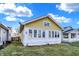 Charming yellow home with a green lawn and a view of the neighboring homes at 2335 Union St, Indianapolis, IN 46225