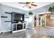 Living room with a ceiling fan, wood-look flooring, wood accent wall, and view of the kitchen at 2335 Union St, Indianapolis, IN 46225