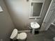 Bathroom with white pedestal sink, toilet, and gray flooring at 416 N Mulberry St, Muncie, IN 47305