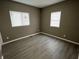 Bedroom featuring gray walls, wood-look flooring, and two windows at 416 N Mulberry St, Muncie, IN 47305