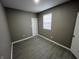 Empty bedroom with gray walls, white trim, and gray wood-look flooring at 416 N Mulberry St, Muncie, IN 47305
