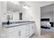 Elegant Primary bathroom with white cabinets, double vanity, granite countertop, and view to bedroom at 5655 Lighthouse Dr, Brownsburg, IN 46112