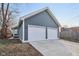 Two-car garage with gray siding, white doors, and a concrete driveway at 620 N Rural St, Indianapolis, IN 46201