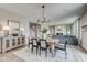 Dining area open to the living room and staircase, featuring a wooden table and chandelier at 67 Sterling Pl, New Whiteland, IN 46184