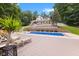Home exterior with pool, deck, and mature trees, seen from a low angle at 7701 Center Lake Rd, Nineveh, IN 46164