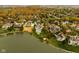 Aerial view of a lakefront community showcasing homes with fall foliage at 8804 Waterside Dr, Indianapolis, IN 46278