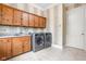 Laundry room with washer, dryer, and wood cabinets at 8804 Waterside Dr, Indianapolis, IN 46278