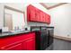 Laundry room with red cabinets, black countertops, and matching washer and dryer at 8804 Waterside Dr, Indianapolis, IN 46278