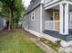 Side view of a two-story home with gray siding and a small white porch at 1125 Congress Ave, Indianapolis, IN 46208