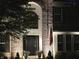 Close-up of home's front entrance with brick exterior, arched window, and American flag at 12004 Tavernier Dr, Fishers, IN 46037