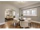 Dining area with a glass-top table, white chairs, and large windows providing natural light at 2558 S Meridian St, Indianapolis, IN 46225