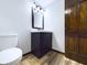 Updated bathroom with dark vanity, modern fixtures, and wood-style flooring at 2604 Albert St, Anderson, IN 46012