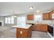 Eat-in kitchen with island, wood cabinets, and view of the living area at 302 Fairfax Ln, Greenwood, IN 46142