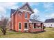 Side view of the brick home showcasing the porch and yard at 321 N State St, Greenfield, IN 46140