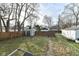 Fenced backyard with storage shed, grassy area, and surrounding neighborhood houses at 3458 N Kenwood Ave, Indianapolis, IN 46208