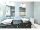 Bathroom with double sinks, black vanity, and light blue walls at 3458 N Kenwood Ave, Indianapolis, IN 46208