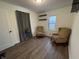 Spacious bedroom with two armchairs and wood-look flooring at 3919 E 34Th St, Indianapolis, IN 46218