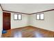 Spacious bedroom with hardwood floors, two windows, and white walls at 5621 Sugar Hills Dr, Greenfield, IN 46140