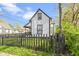 Picturesque exterior elevation showcasing the home's charming facade, fenced yard, and mature trees at 1176 Udell St, Indianapolis, IN 46208