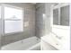 Modern bathroom with tiled shower, white vanity, and frosted window at 401 N Chester Ave, Indianapolis, IN 46201