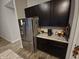 Stainless steel refrigerator and dark wood kitchen cabinets at 4411 Ringstead Way, Indianapolis, IN 46235