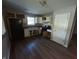Compact kitchen with white cabinetry, black appliances, and wood-look flooring at 6215 E 11Th St, Indianapolis, IN 46219