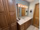 Bathroom with vanity, large mirror, and wood cabinets at 712 Gettysburg Ct, Indianapolis, IN 46217