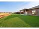 Large backyard with lush lawn and brick home with covered patio at 202 Asbury Dr, Anderson, IN 46013