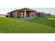 Spacious backyard with grassy lawn and brick home with covered patio at 202 Asbury Dr, Anderson, IN 46013