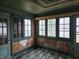 Another view of the sunroom with damaged walls and flooring at 2402 N B St, Elwood, IN 46036