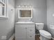 Modern bathroom with white vanity, updated fixtures and gray tile at 2941 Taylor Rd, Columbus, IN 47203