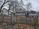 Rear view of a house with a wooden fence and leaf covered yard at 3609 E Washington St, Indianapolis, IN 46201