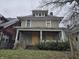 Two-story house needing renovation, featuring a front porch and boarded windows at 3609 E Washington St, Indianapolis, IN 46201