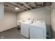 Clean basement laundry area, featuring washer, dryer, and utility sink at 5493 E 18Th St, Indianapolis, IN 46218